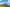 Photovoltaik- und Windkraftanlage auf einer grünen Wiese bei blauem Himmel.