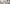 Mann sitzt entspannt mit seinem Hund im Wohnzimmer und hat ein Smartphone in der Hand.